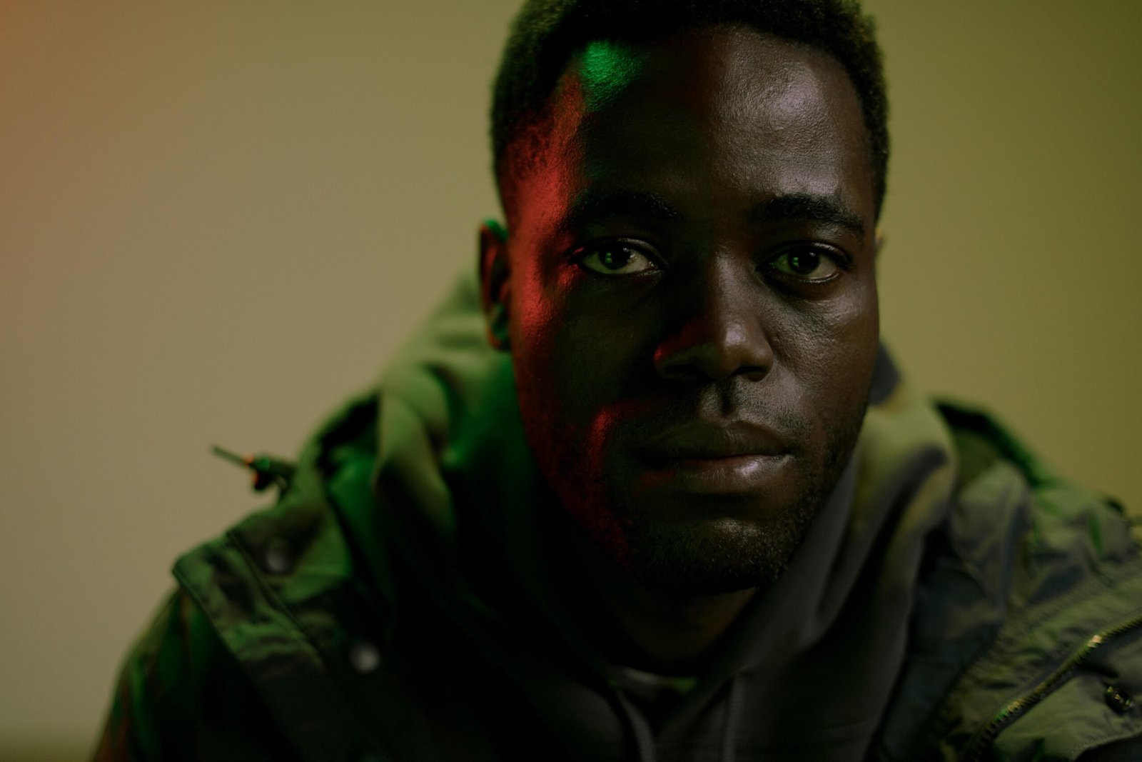 A close-up portrait of an African man with a contemplative expression in creative lighting.
